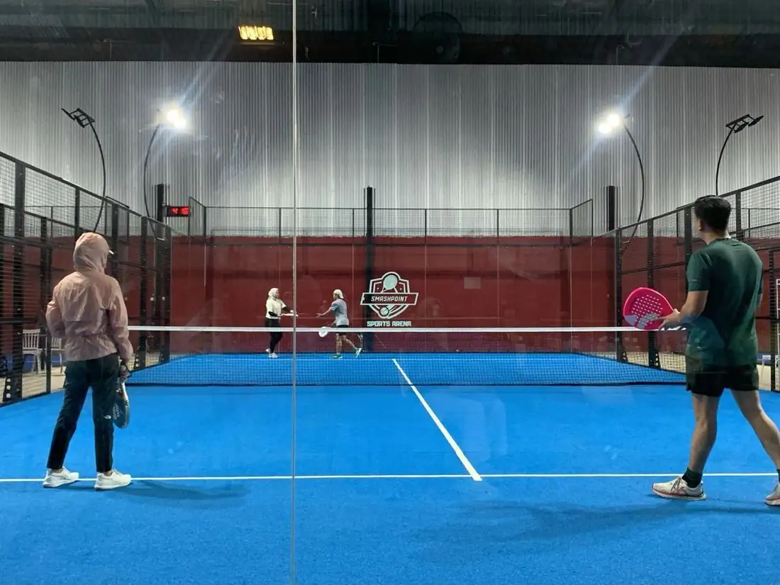Blue padel court with the Smashpoint crest on the back wall